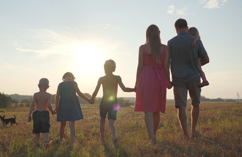 A family of 6 outfoors, looking at the sun