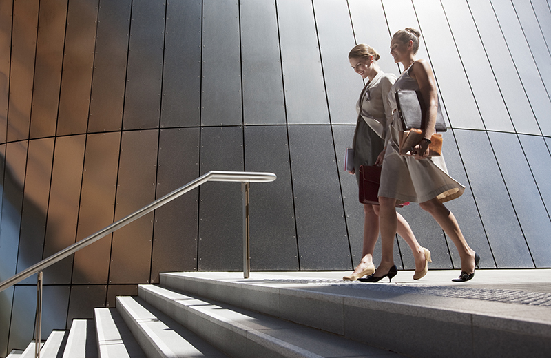  Two professional women walking towards stairs