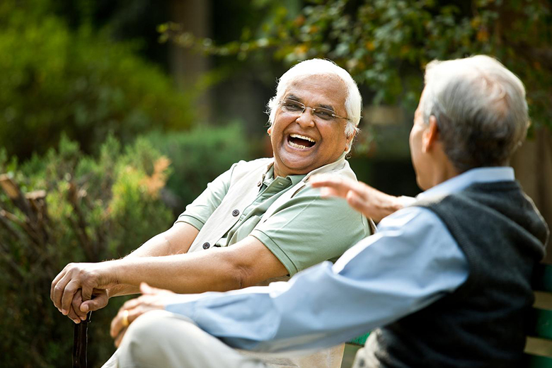 Two older men sitting and laughing